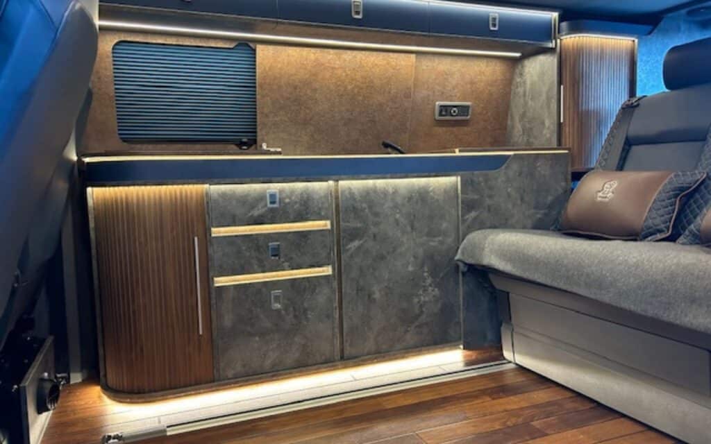 Modern luxury van interior with custom cabinetry and seating.