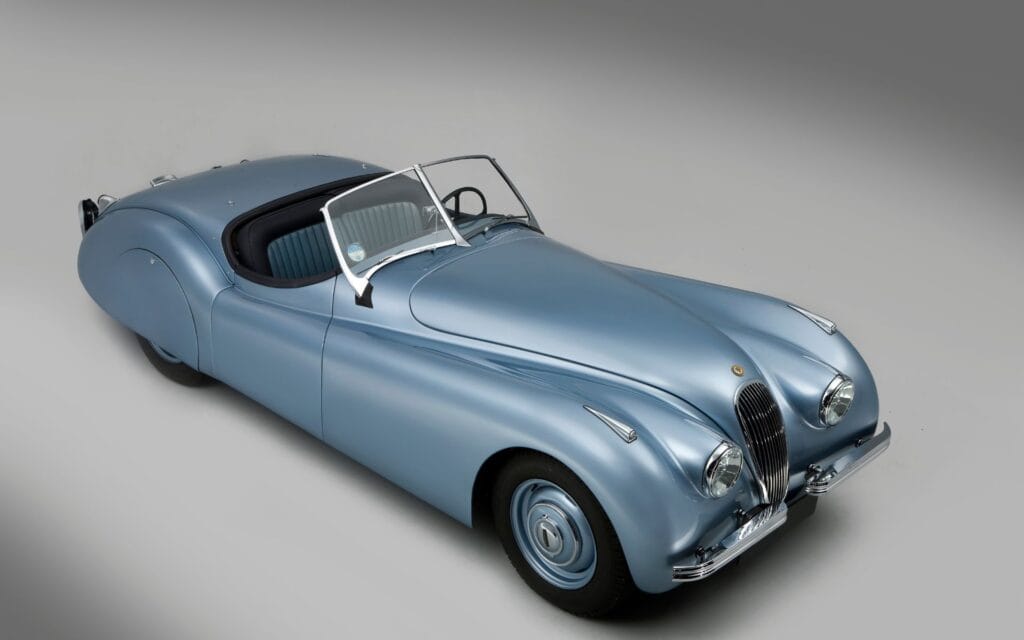 Classic silver vintage car with sleek design and rounded features.