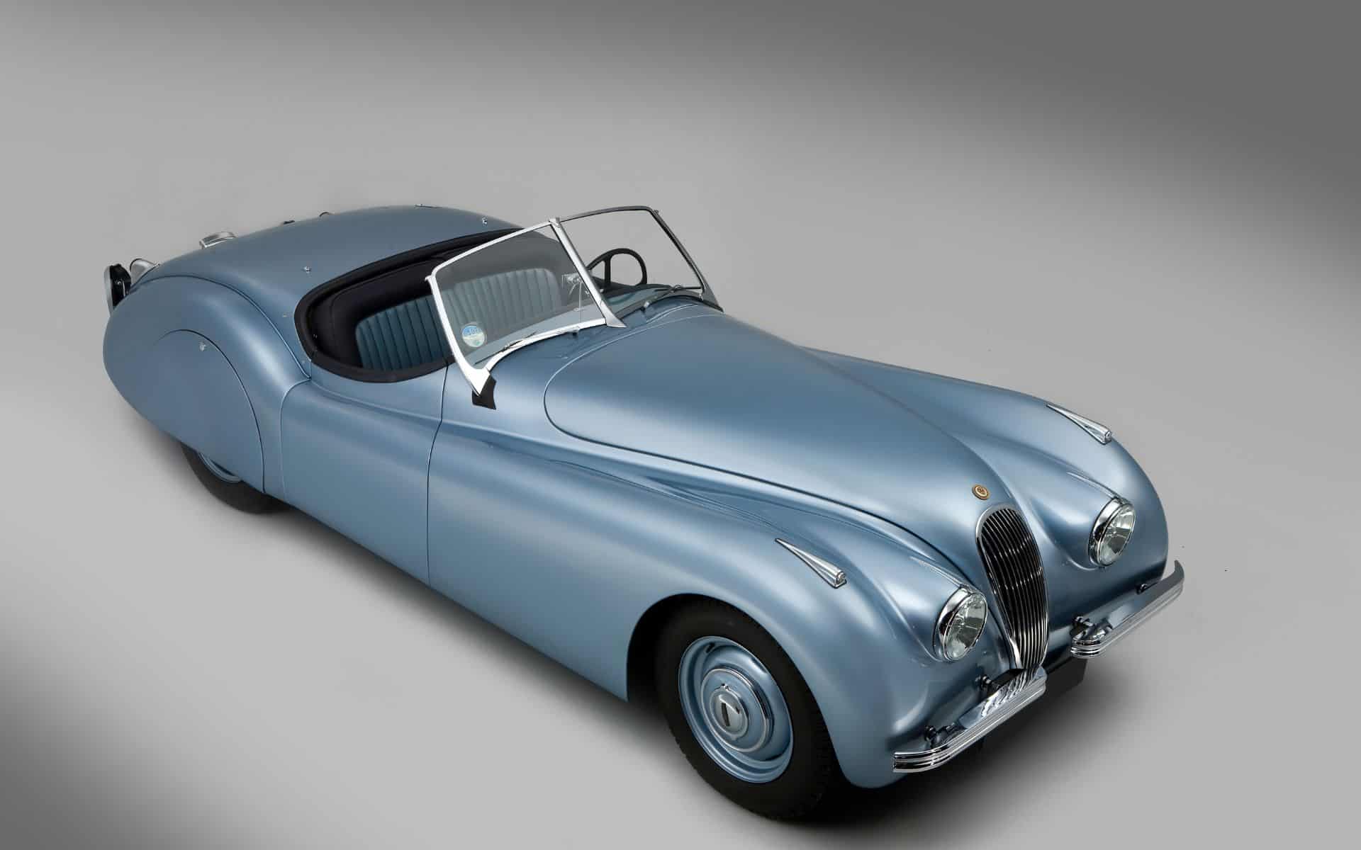 Classic silver vintage car with sleek design and rounded features.